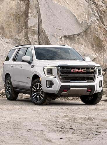 A white 2023 GMC Yukon parked off-road.