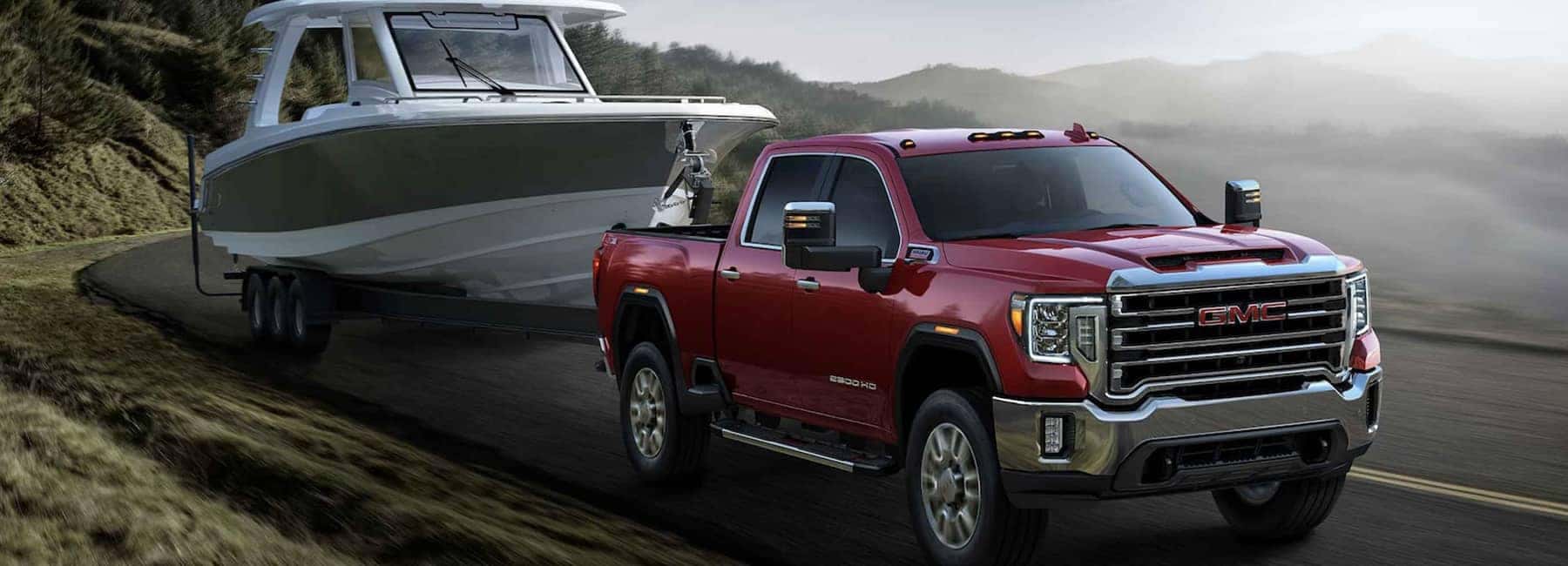 A red 2023 GMC Sierra Heavy Duty towing a boat.