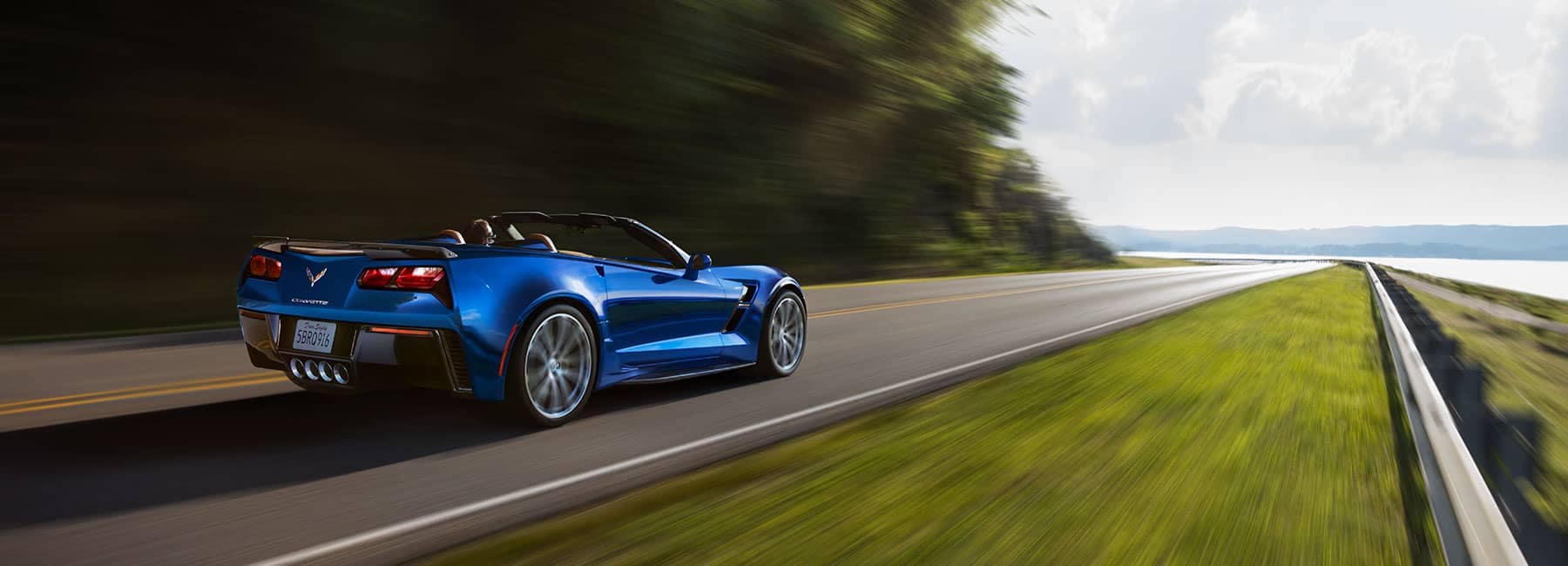 Blue Chevrolet Corvette driving on a road