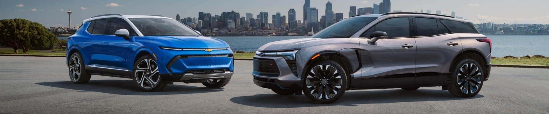 Blue Chevy Equinox EV and a grey Chevy Blazer EV parked near water