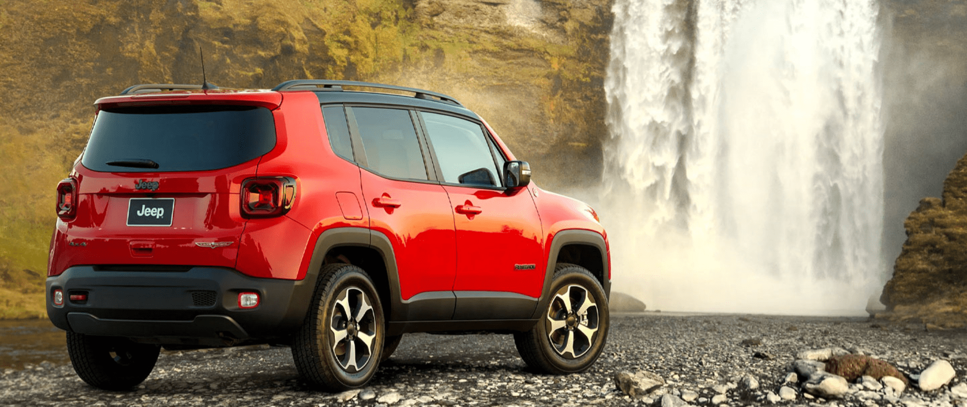 red Renegade parked with waterfall in background