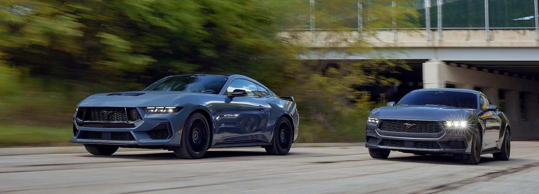 Two Mustangs driving along the highway