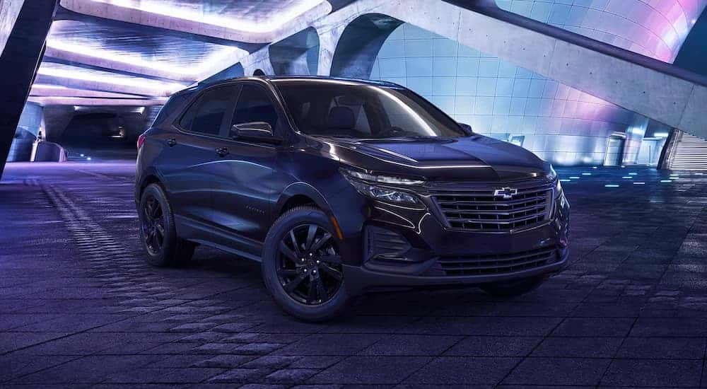 A black 2023 Chevy Equinox Midnight Edition parked in a city at night