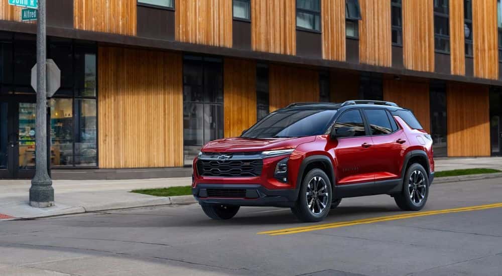 A red 2025 Chevy Equinox RS parked at an intersection.