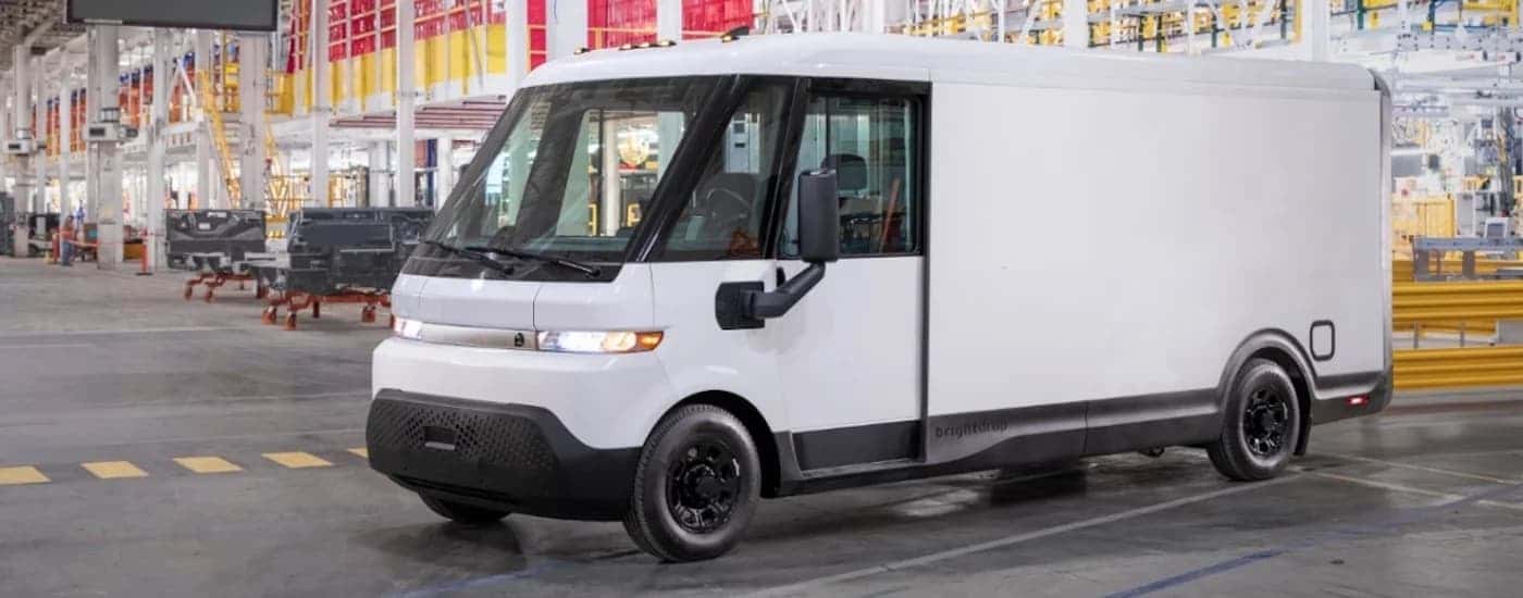A white 2025 Chevy BrightDrop van parked inside a warehouse and angled left.