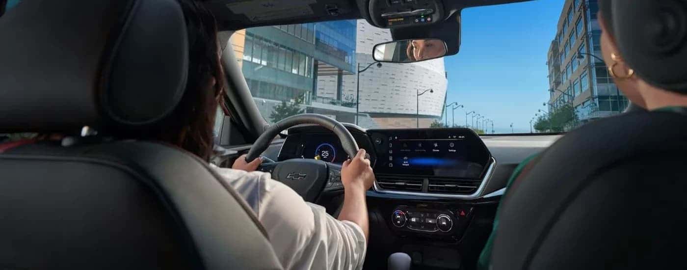 An interior view of a woman driving a 2024 Chevy Trax.
