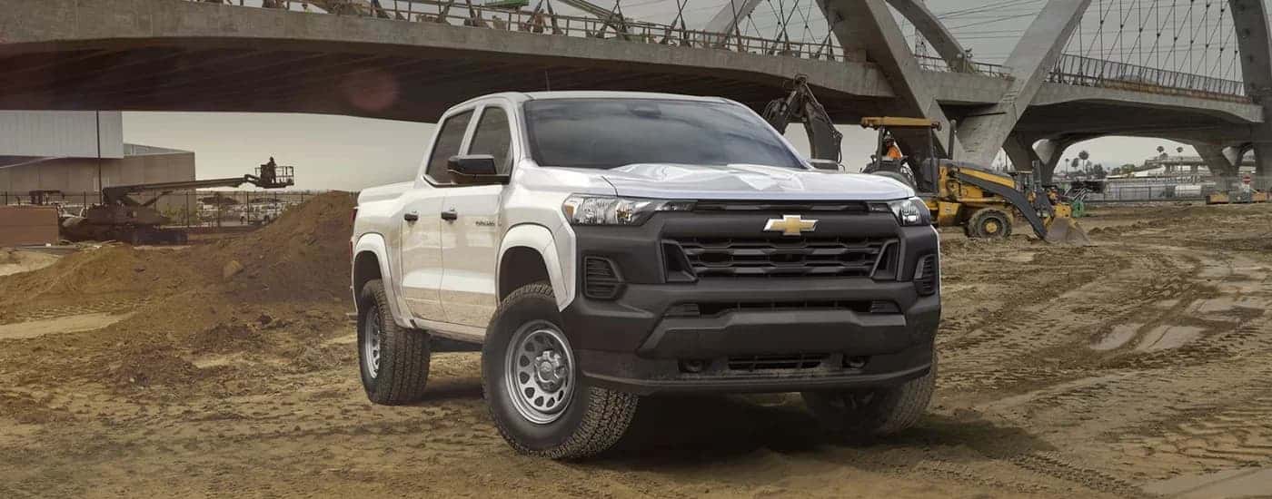 A white 2024 Chevy Colorado WT parked near a bridge.