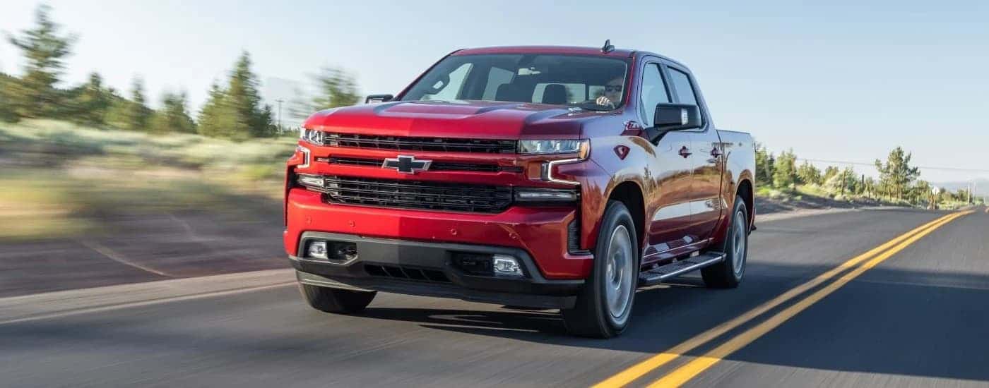 Red used 2020 Chevy Silverado 1500 Z71 for sale near Houston driving down a road.