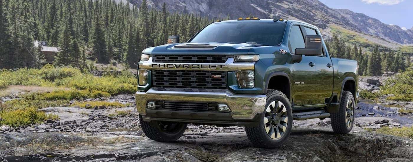 Right angled view of a blue 2020 Chevy Silverado 2500 HD Z71 parked off-road in a valley.