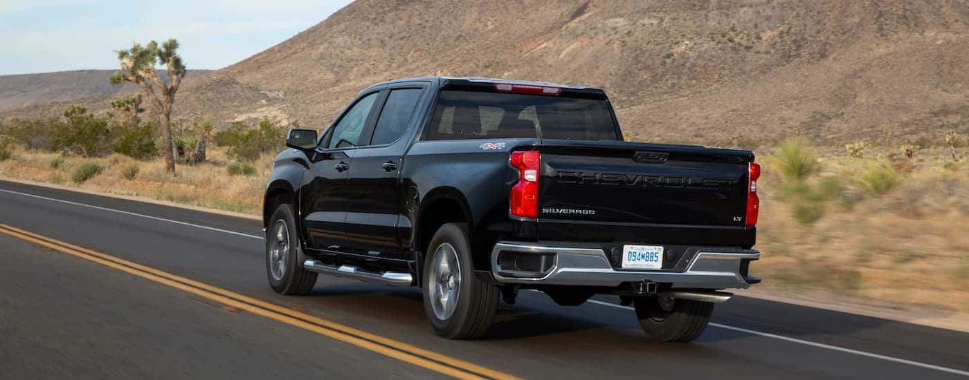 A black 2022 Chevy Silverado 1500 from the rear at an angle after leaving a dealer that has used trucks for sale near Fulshear.