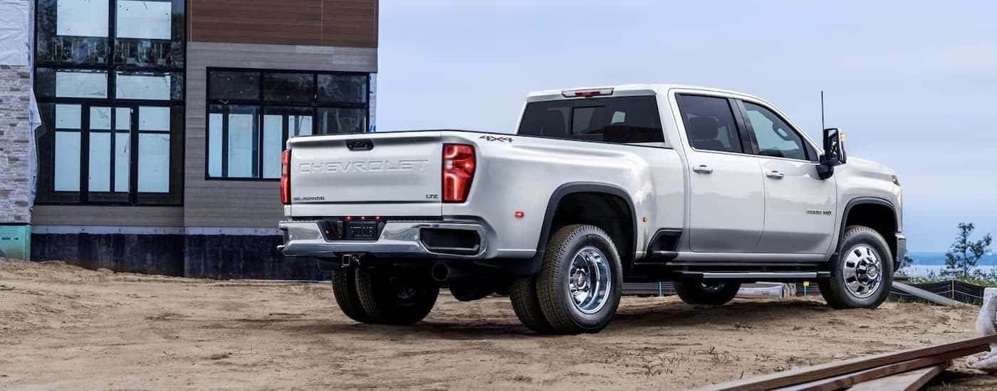 A white 2024 Chevy Silverado 3500HD is shown from a rear angle parked on a construction site