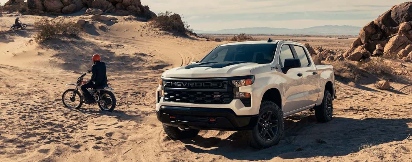 A white 2023 Chevy Silverado for sale near Cypress is shown off-road.