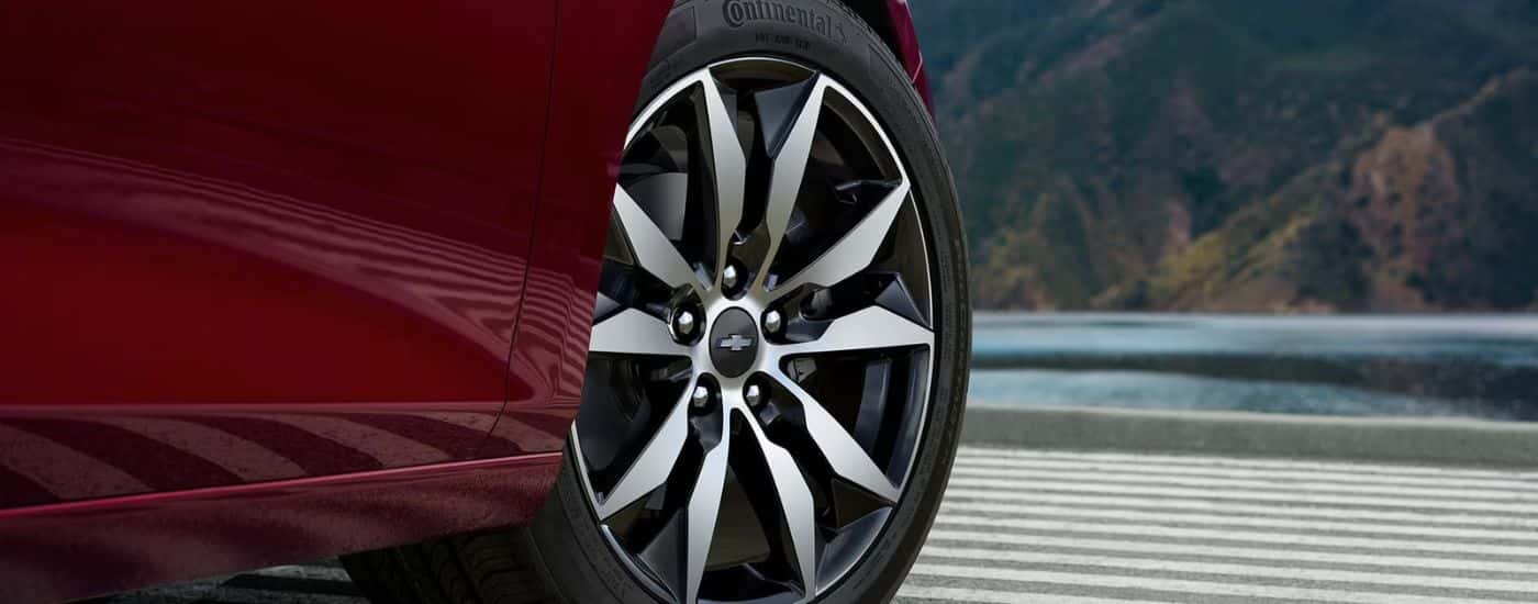 A close up shows a wheel on a red 2023 Chevy Malibu.