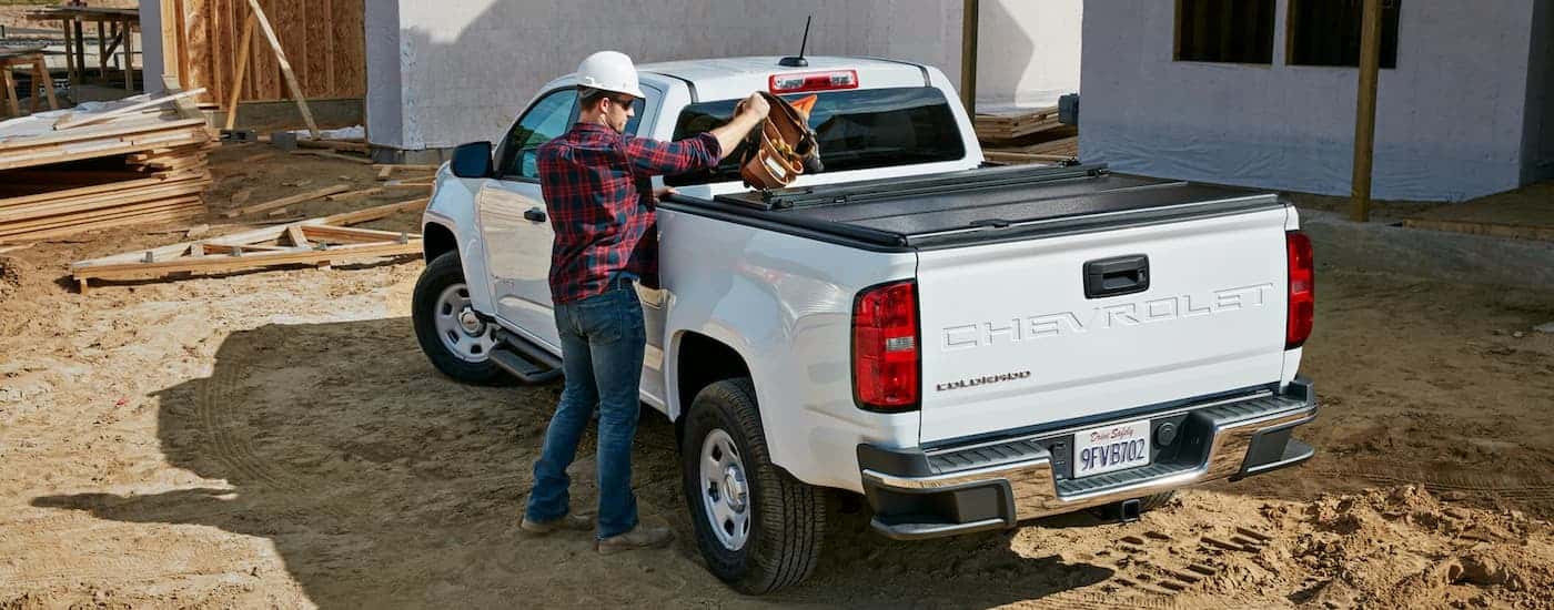 A white 2022 Chevy Colorado is shown parked at a construction site after leaving a used truck dealer near The Woodlands