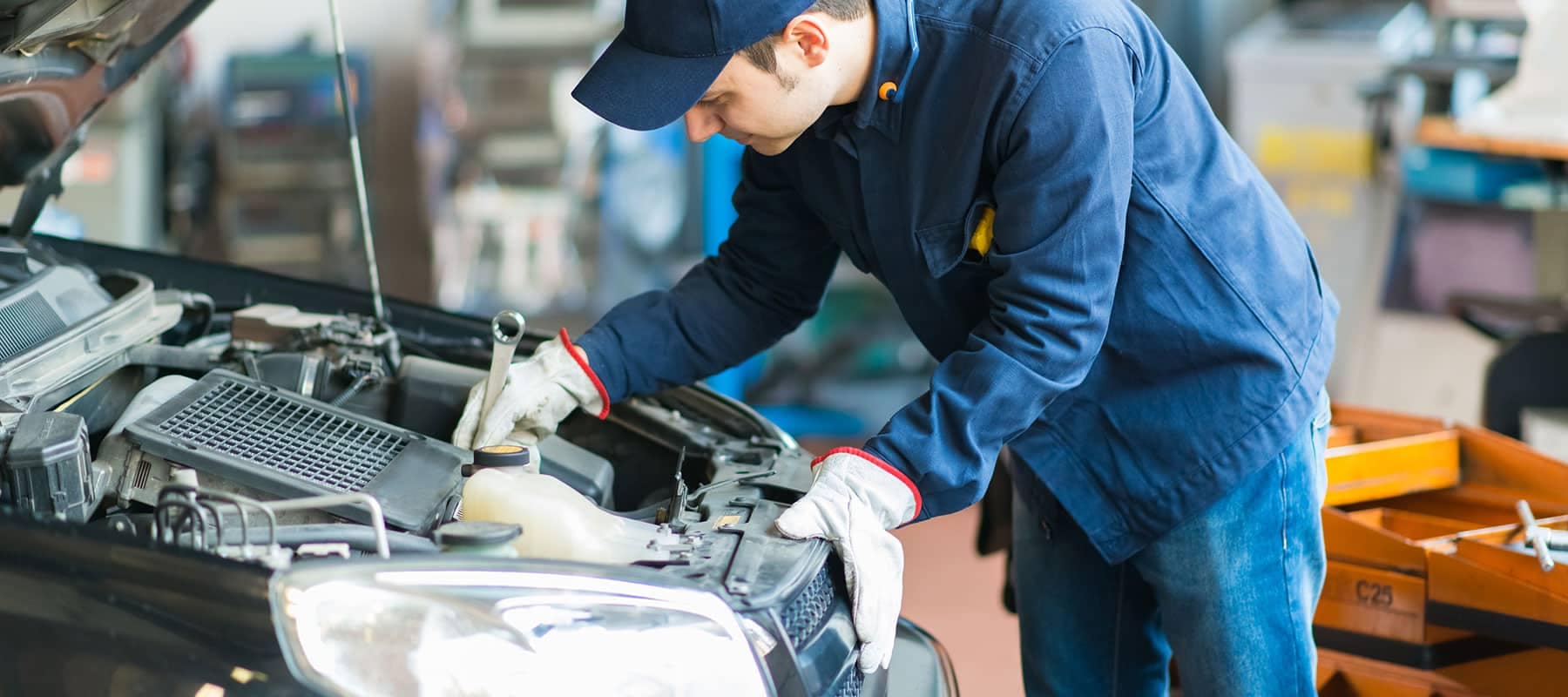 Service picture of technician working on car engine with a wrench