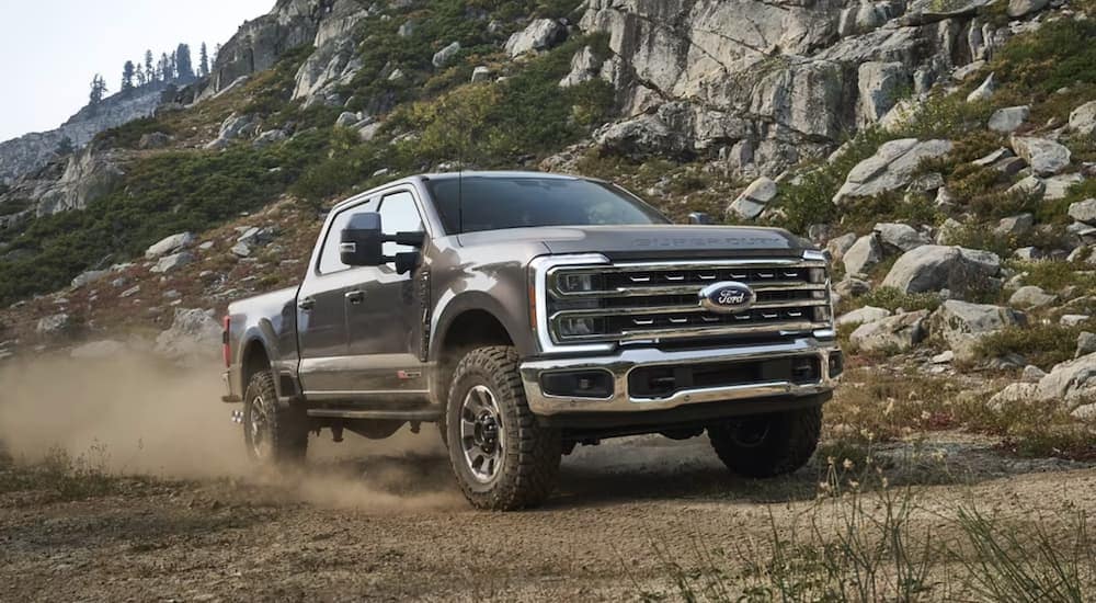 A grey 2023 Ford F-350 is shown from the front off-roading.