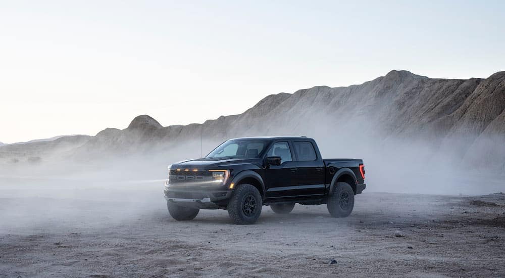 A black 2021 F-150 Raptor is shown from the side after leaving a used Ford dealership.