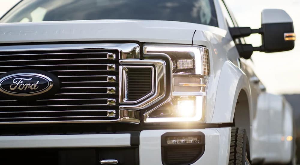 A white 2022 Ford F-350 Super Duty is shown from the front after leaving a Owosso Ford dealer.