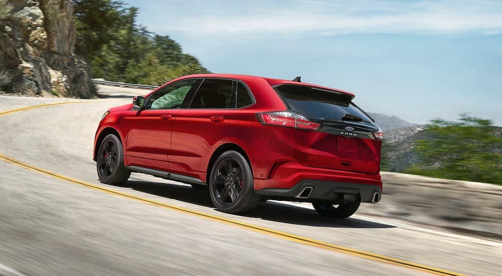 A red 2021 Ford Edge is shown from the rear driving on an open road.
