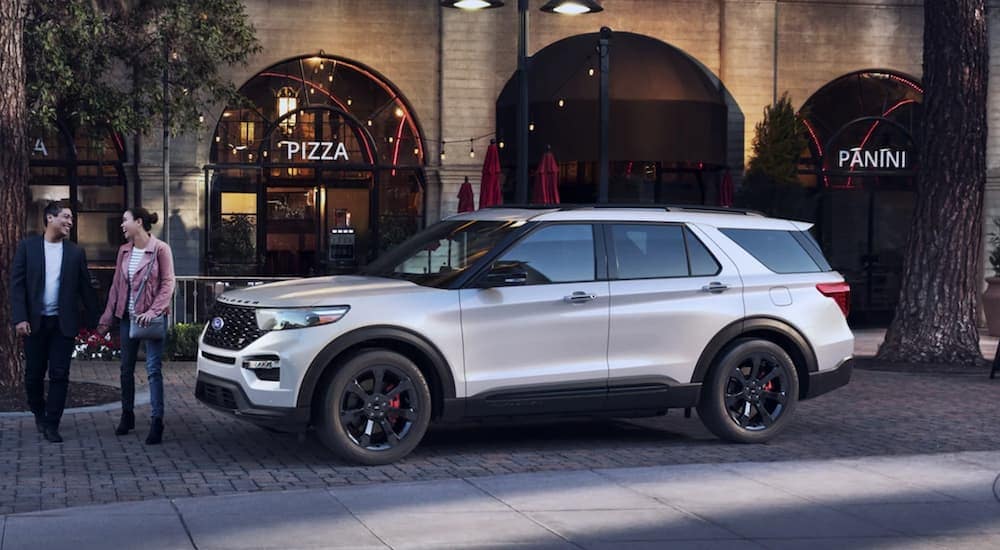 A white 2022 Ford Explorer ST is shown from the side parked in front of a restaurant.