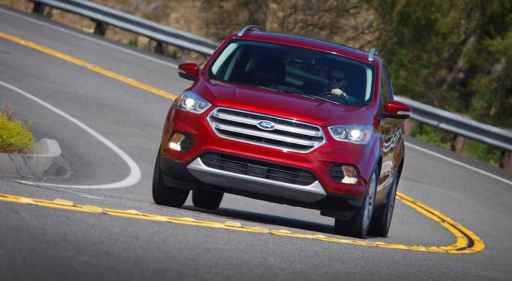 A red 2017 Ford Escape is shown from the front while rounding a corner.