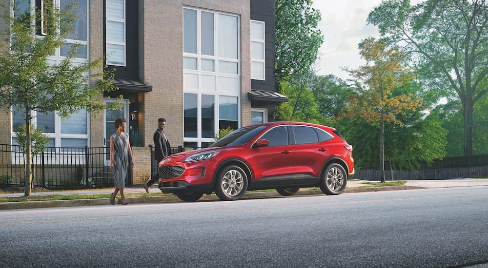A red 2022 Ford Escape is shown from the side on a city street.