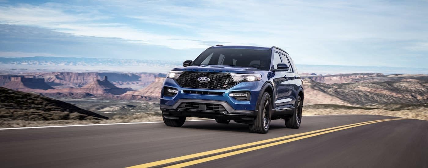 A blue 2020 Ford Explorer ST is shown driving on an open road.