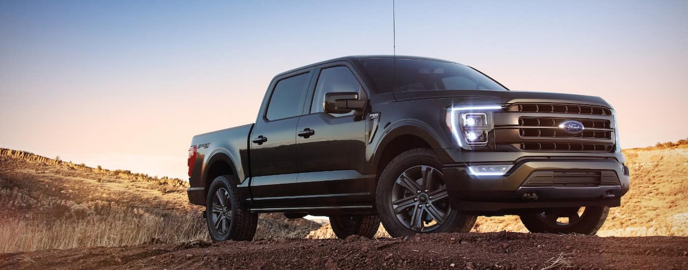 A black 2022 Ford F-15 Lariat is shown parked on a dirt lot.