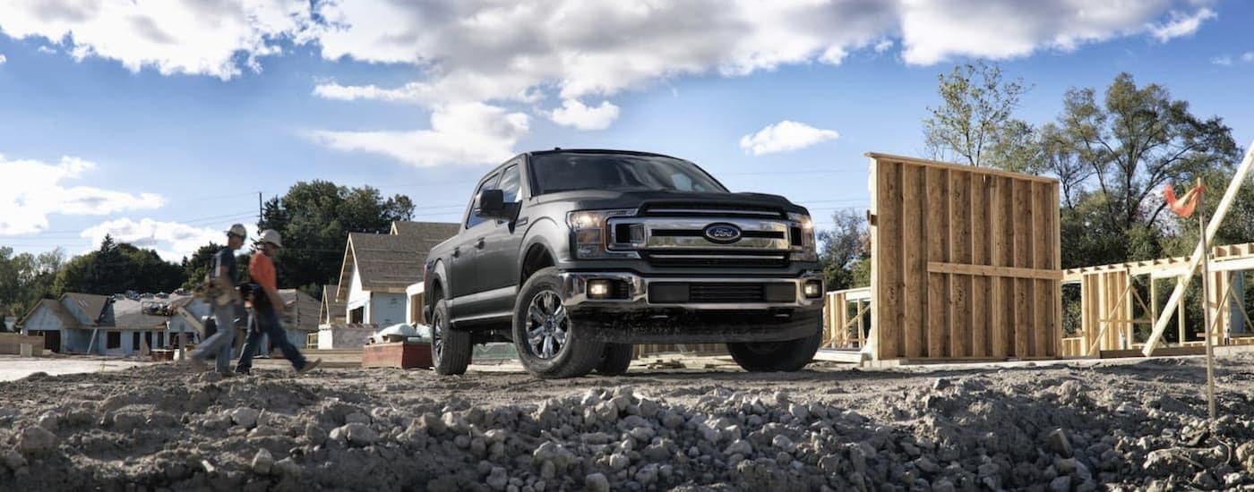 A grey 2018 Ford F-150 is shown from the front parked at a construction site.