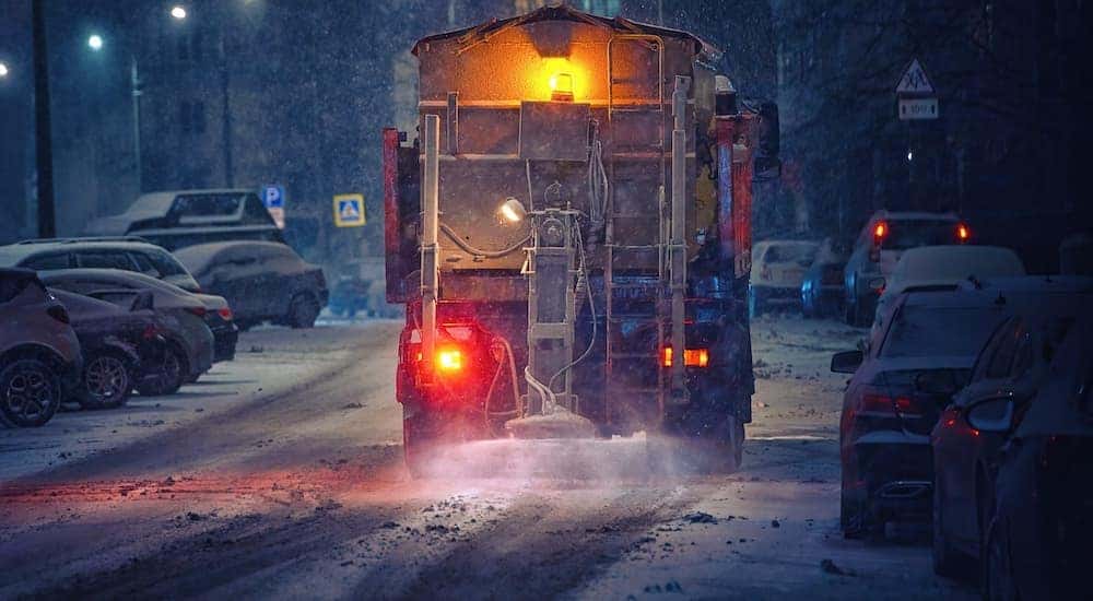 A salt truck is shown on a winter road.