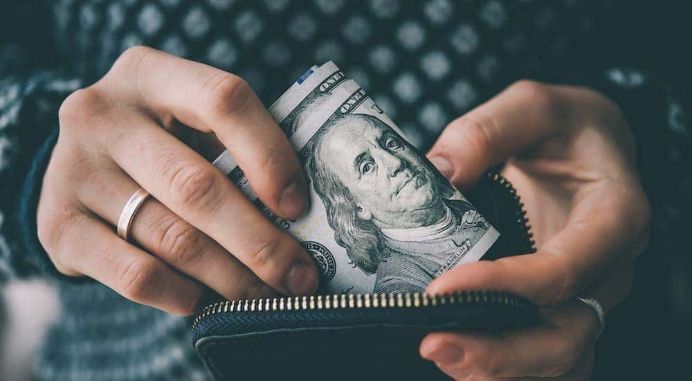 A person is shown holding cash.
