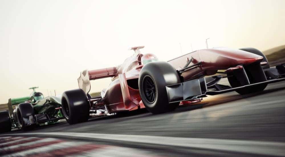 A racecar is shown racing on a race track.