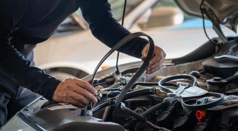 A mechanic is shown replacing a timing belt.