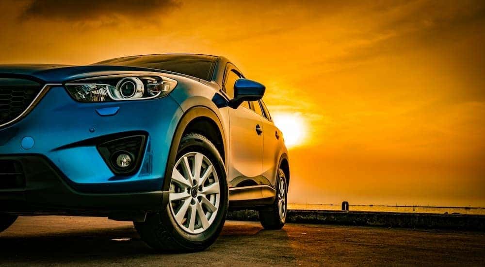 A car is shown parked under the sun.