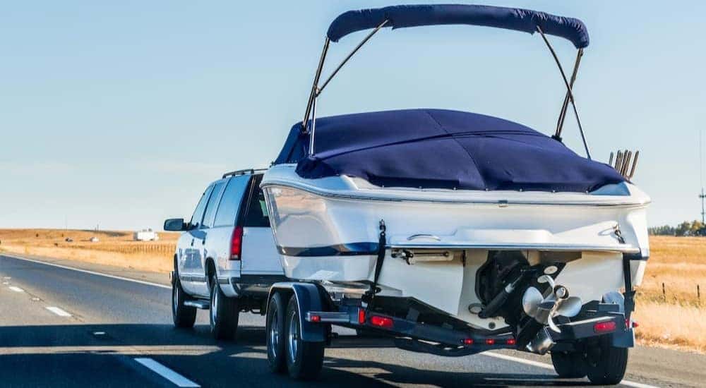 An SUV is shown towing a boat.