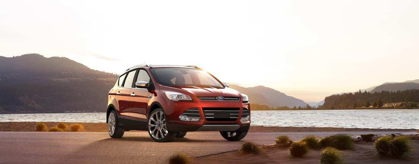 A red 2017 Ford Escape is shown parked next to a lake.