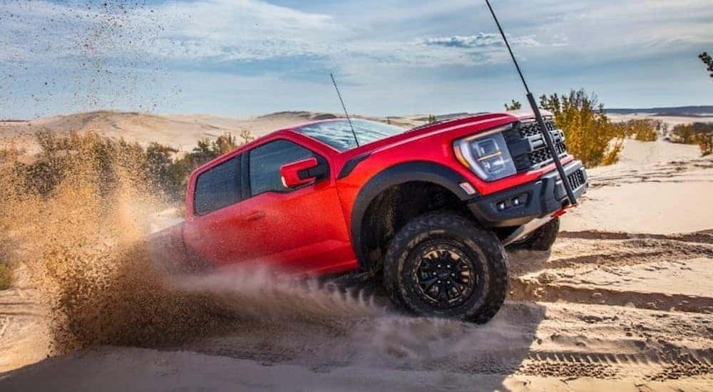 A Ford F-150 Raptor R is shown off-roading in the sand.