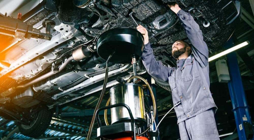 A mechanic is shown completing an oil change.