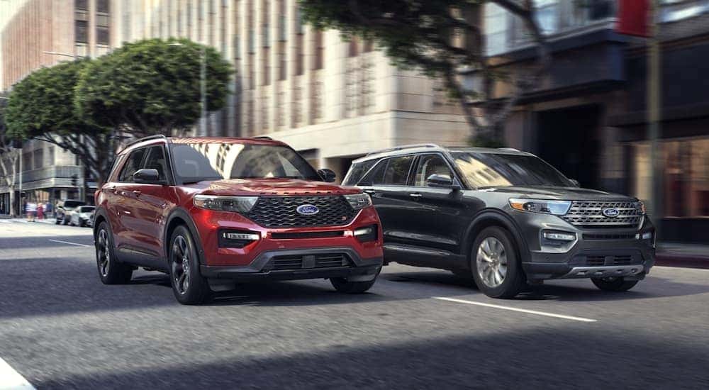 A red 2020 Ford Explorer ST is shown driving next to a grey 2020 Ford Explorer.
