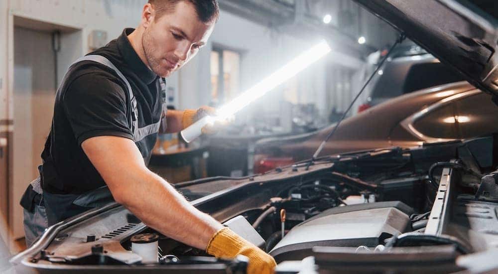 A mechanic is shown working on a vehicle.
