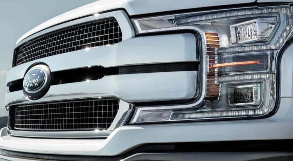 A close up shows the grille on a white 2020 Ford F-150.
