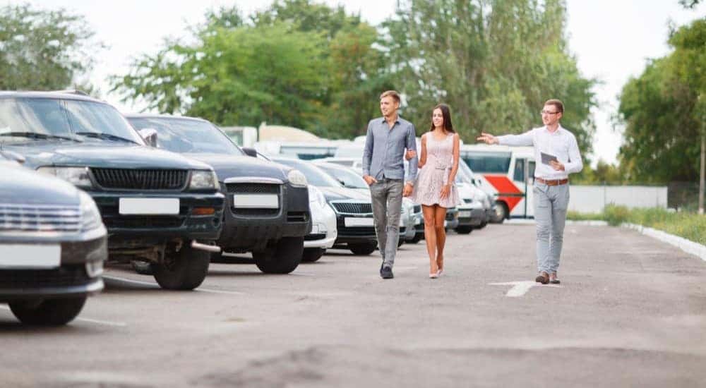 A customer is shown being helped in a used car lot.