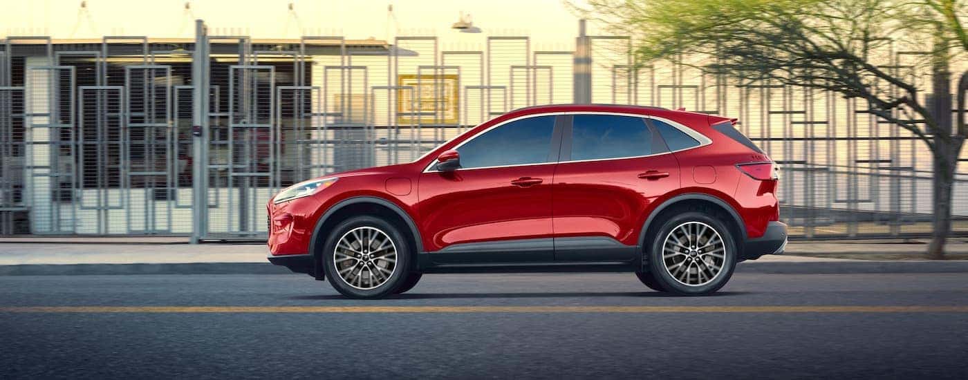 A red 2020 Ford Escape is shown from the side parked on a city street.