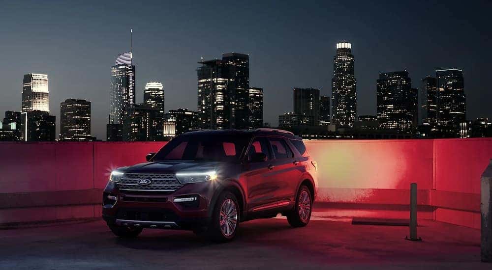 A black 2022 Ford Explorer Hybrid is shown parked on a city rooftop garage at night.