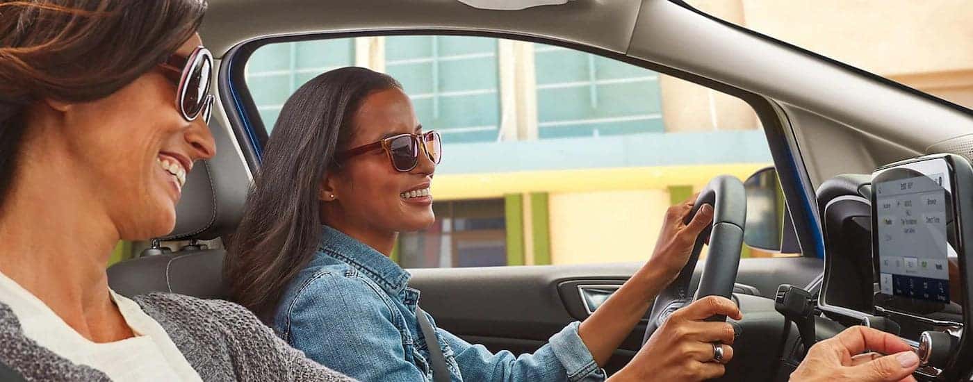 Two friends are shown driving a 2022 Ford EcoSport through a city.