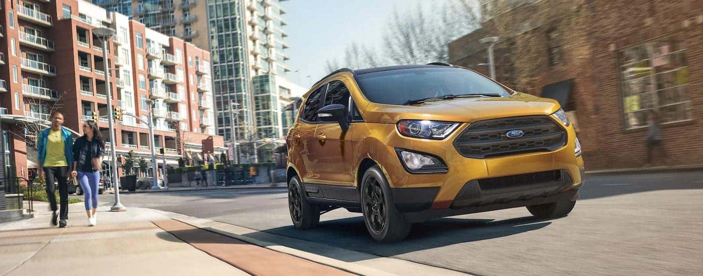 A gold 2022 Ford EcoSport is shown on a city street after leaving a Ford dealership near you.
