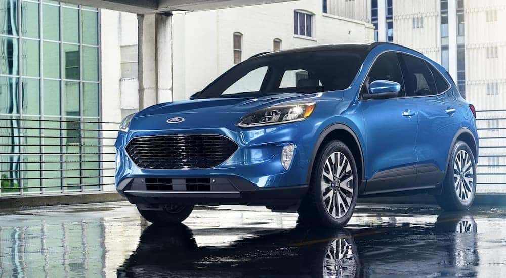 A used car for sale near you, a blue 2021 Ford Escape Titanium, is shown parked in a garage.