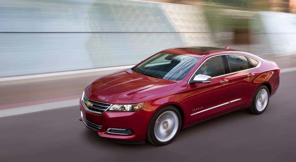 A red 2018 Chevy Impala LTZ is shown from the side on a city street.
