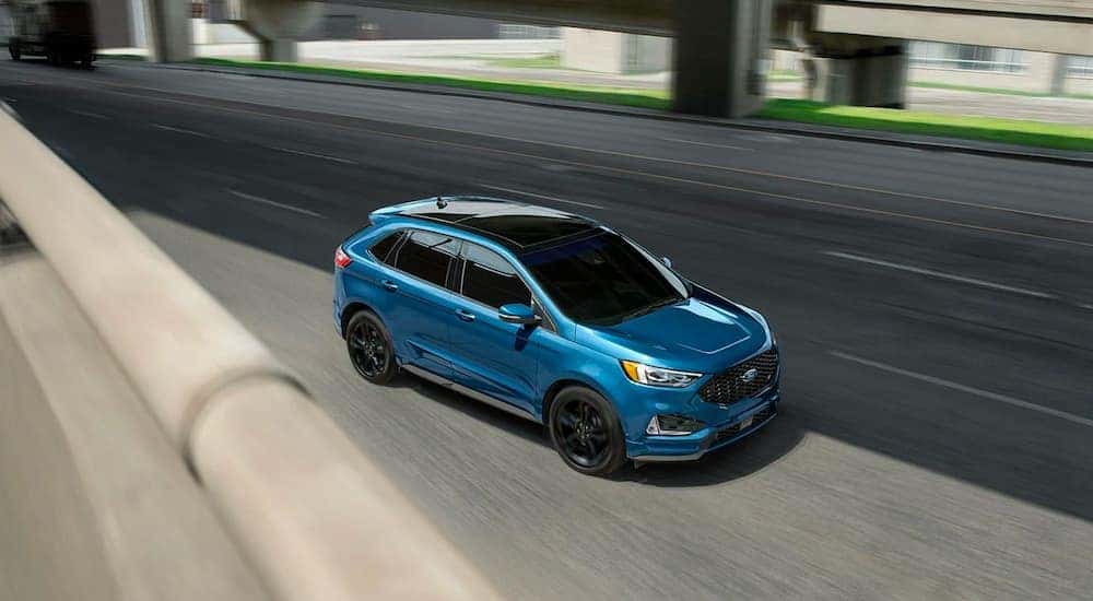 A blue 2020 Ford Edge ST is shown on a highway.