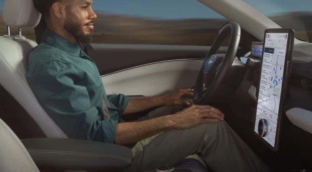 A person is shown using the Blue Cruise feature in a 2023 Ford Mustang Mach-E.
